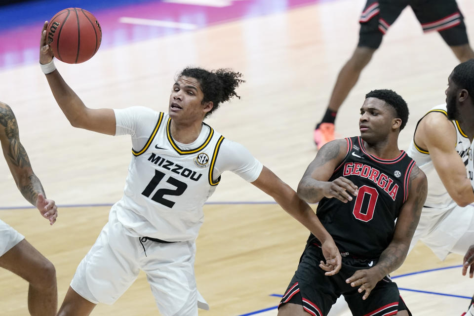 Missouri's Dru Smith (12) pulls in a rebound ahead of Georgia's K.D. Johnson (0) in the first half of an NCAA college basketball game in the Southeastern Conference Tournament Thursday, March 11, 2021, in Nashville, Tenn. (AP Photo/Mark Humphrey)