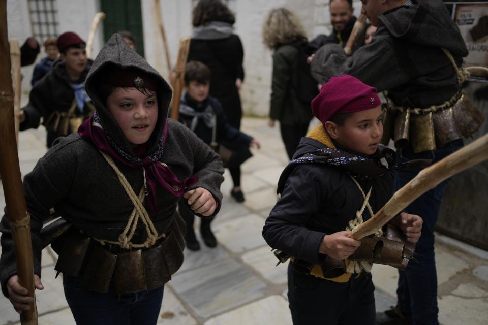 Young bell ringers (Koudounatoi) dance during a traditional custom, in the village of Apeiranthos, on the Aegean Sea island of Naxos, Greece, on Sunday, Feb. 26, 2023. The first proper celebration of the Carnival after four years of COVID restrictions, has attracted throngs of revellers, Greek and foreign, with the young especially showing up in large numbers. (AP Photo/Thanassis Stavrakis)