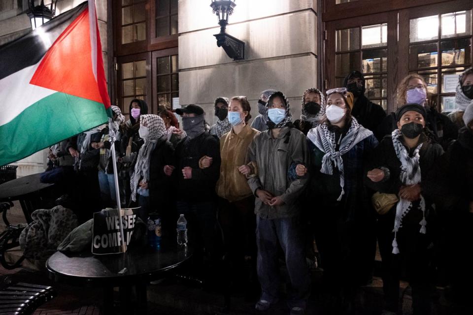 Pro-Palestinian students lock arms, sing and chant as they braced for New York Police Department officers to raid campus on 30 April. (AP)