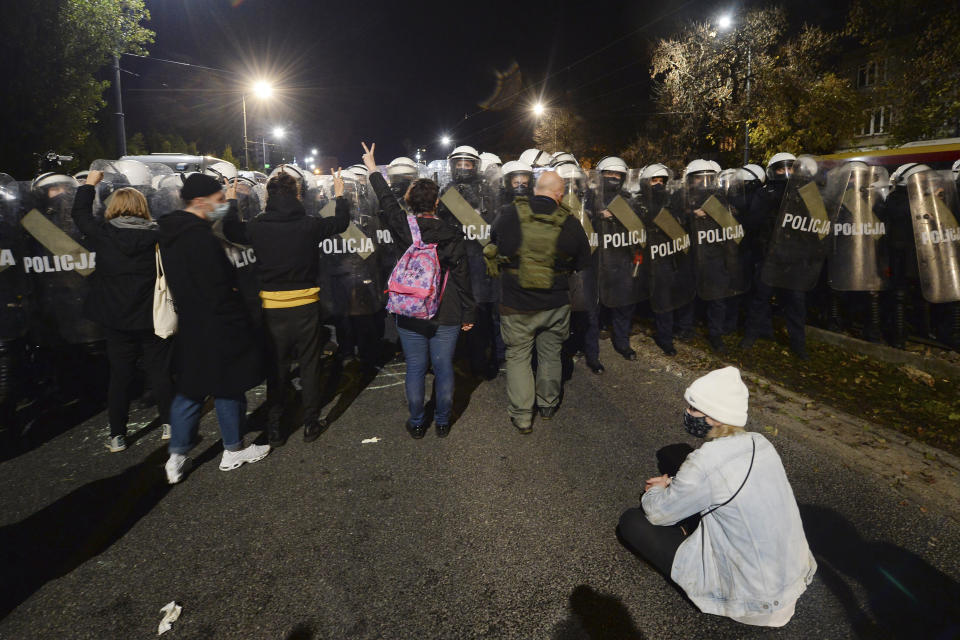 A police cordon guards the house of Poland's ruling conservative party leader Jaroslaw Kaczynski against a crowd protesting a decision by the Constitutional Court, in Warsaw, Poland, on Friday, Oct. 23, 2020. Poland’s top court ruled Thursday that a law allowing abortion of fetuses with congenital defects is unconstitutional, shutting a major loophole in the predominantly Catholic country's abortion laws that are among the strictest in Europe. Defying the pandemic-related ban on gatherings, the protesters chanted for the government to resign. (AP Photo/Czarek Sokolowski)