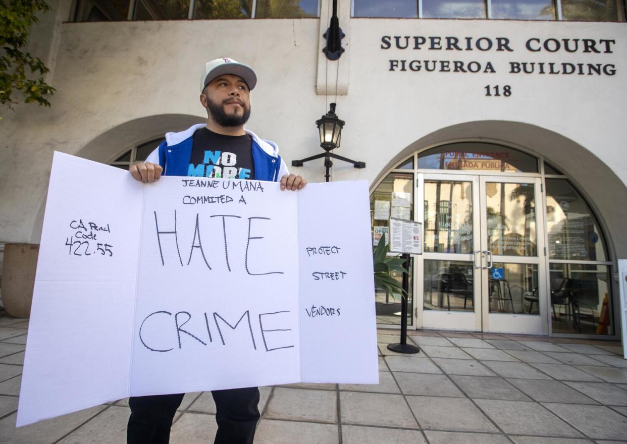 A man holds a sign on poster board.