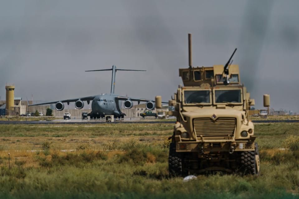 A truck sits near the airport where a large plane prepares to take off.