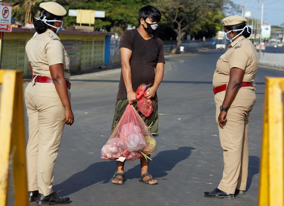 A man carrying vegetables is stopped by police at a barricade on a road during a 21-day nationwide lockdown to limit the spreading of coronavirus disease (COVID-19) in Chennai, India, March 25, 2020. REUTERS/P. Ravikumar