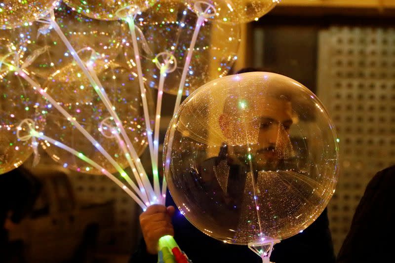 A man holds balloons at Manger Square in Bethlehem in the Israeli-occupied West Bank