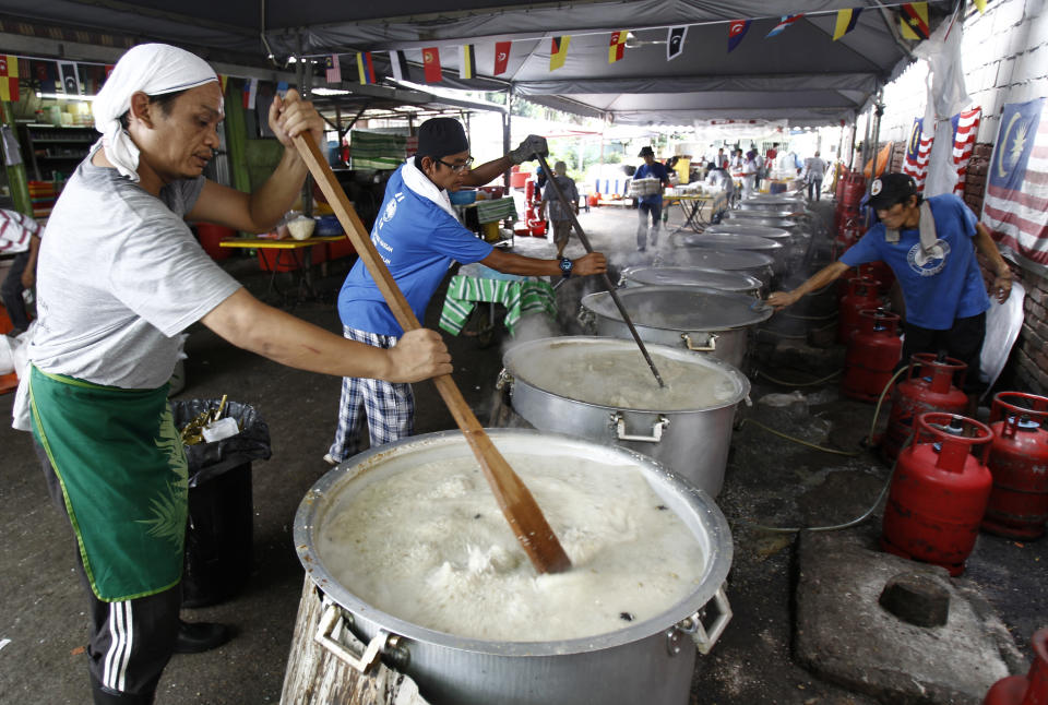 FILE - Malaysian Muslims cook large pots of Bubur Lambuk porridge in the Kampung Baru village in Kuala Lumpur, Malaysia on June 1, 2017. Malaysia's government said Monday, Oct. 2, 2023, the country that enough rice is available and urged people not to hoard locally produced rice after recent panic-buying led to empty shelves in supermarkets and grocery stores nationwide. (AP Photo/Daniel Chan, File)