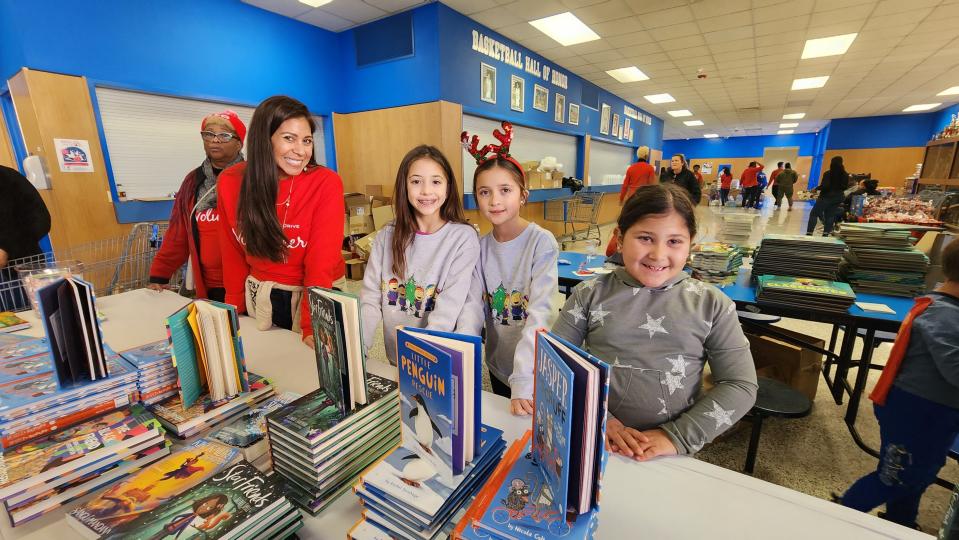 Young volunteers pass out books Saturday at the 10th annual North Side Toy Drive held at the Palo Duro High School Gym in Amarillo.