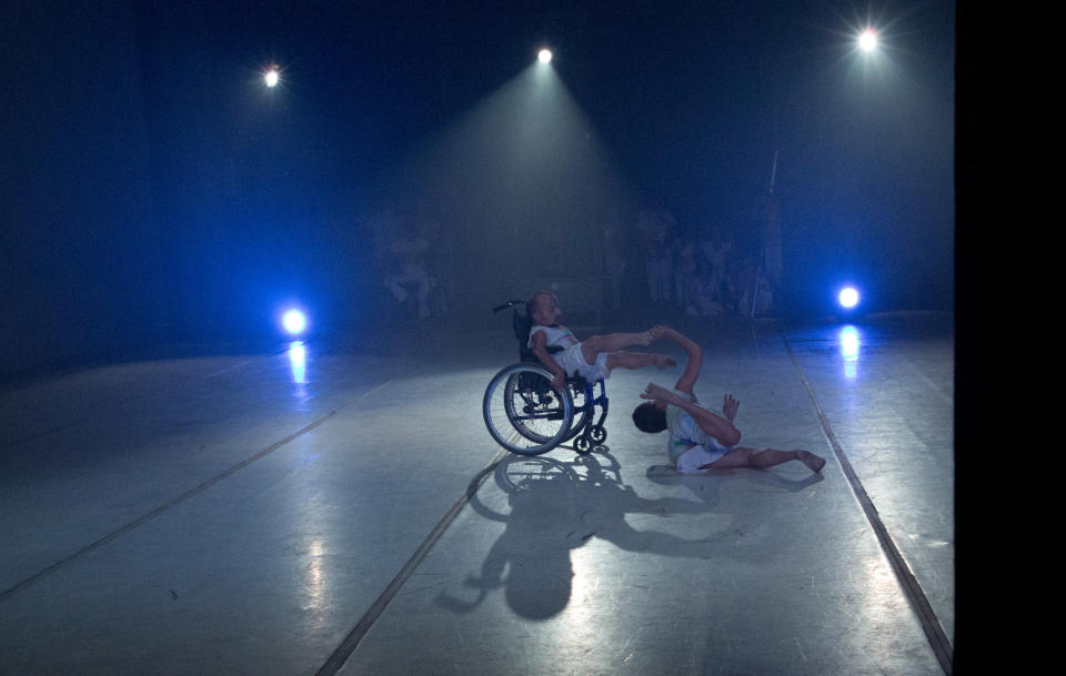 In this Dec. 4, 2018 photo, dancer Sendoa Quijada performs in his wheelchair in the contemporary dance production Ubuntu, at the Teresa Carreno Theater in Caracas, Venezuela. Caracas based AM Danza works with 50 young Venezuelans who are pursuing their passion for dance despite limitations like broken spines, cerebral palsy or blindness. (AP Photo/Fernando Llano)