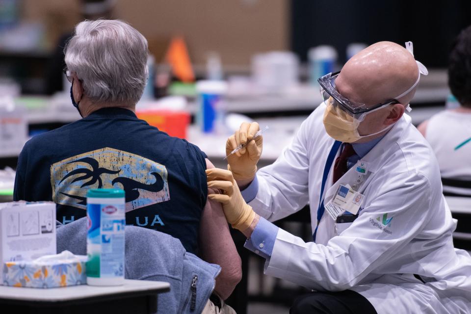 Chief clinical officer John Corman MD at Virginia Mason administers a dose of the Pfizer Covid-19 vaccine at the Amazon Meeting Center in downtown Seattle, Washington on January 24, 2021. - Amazon is partnering with Virginia Mason for a one-day pop-up clinic on January 24. 2021 that aims to vaccinate 2,000 people at the companys Meeting Center near downtown Seattle. Virginia Mason is handling vaccine administration, while Amazon is providing the location and help with logistics. (Photo by Grant HINDSLEY / AFP) (Photo by GRANT HINDSLEY/AFP via Getty Images)