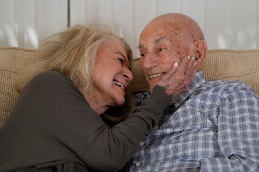 World War II veteran Harold Terens, 100, right, and Jeanne Swerlin, 96, snuggle during an interview, Thursday, Feb. 29, 2024, in Boca Raton, Fla. Terens will be honored by France as part of the country’s 80th anniversary celebration of D-Day. In addition, the couple will be married on June 8 at a chapel near the beaches where U.S. forces landed. (AP Photo/Wilfredo Lee)