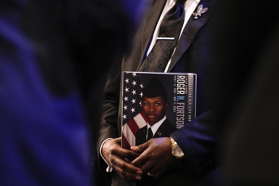A mourner holds a funeral program near the casket of slain airman Roger Fortson during his funeral at New Birth Missionary Baptist Church, Friday, May 17, 2024, near Atlanta. (AP Photo/Brynn Anderson)