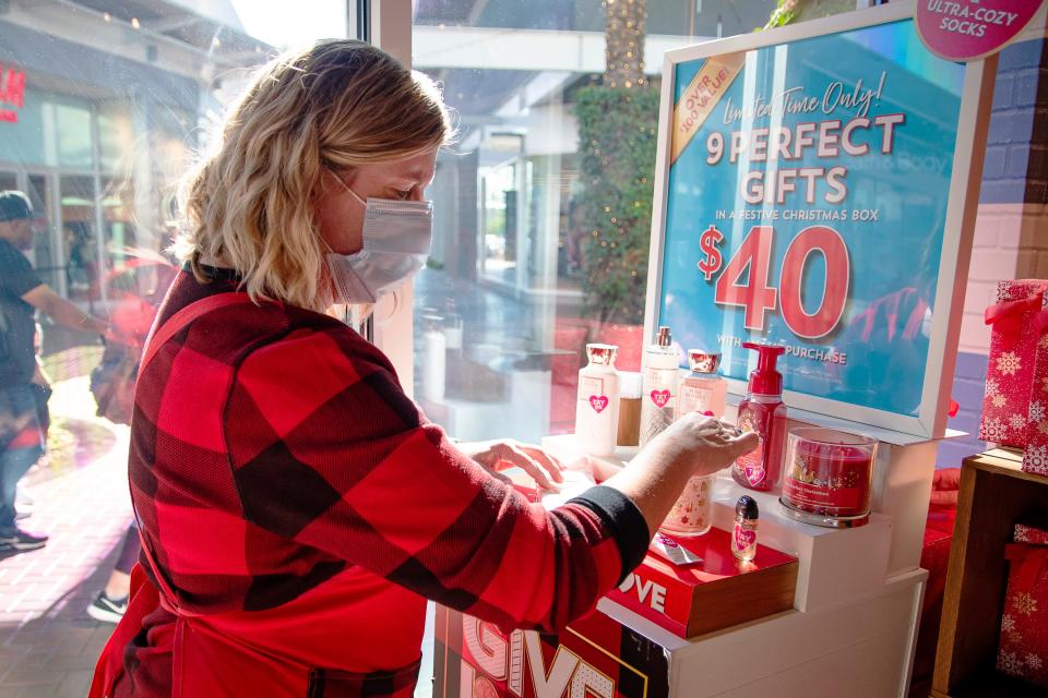 Nancy Folik arranges a gift display inside Bath and Body Works at Tempe Marketplace on Nov. 26, 2021.