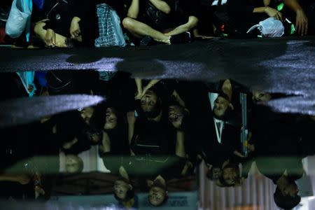 Mourners are reflected as they queue to attend the Royal Cremation ceremony of Thailand's late King Bhumibol Adulyadej near the Grand Palace in Bangkok, Thailand, October 25, 2017. REUTERS/Kerek Wongsa