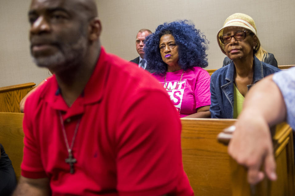 Flint residents Arthur Woodson, Barbie Biggs and Claire McClinton listen on as Genesee District Judge David J. Goggins gives his decision during Nick Lyon's preliminary examination on Monday, Aug. 20, 2018 at Genesee District Court in Flint, Mich. Goggins bound Lyon's case over to Genesee Circuit Court for trial on two counts of involuntary manslaughter for the deaths of Robert Skidmore and John Snyder, who prosecutors say died as a result of Legionnaires' disease, and one count of misconduct in office. He also faces one misdemeanor count of willful neglect of duty. (Jake May/The Flint Journal via AP)