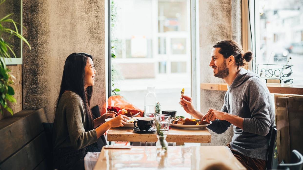 Young interracial couple on a date at the Bistro restaurant on Valentine's Day holiday.