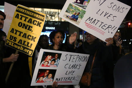 Protesters hold signs and chant slogans as they march in Times Square in the Manhattan borough of New York City, during a protest against the death of Stephon Clark in Sacramento, California, U.S. March 28, 2018. REUTERS/Gabriela Bhaskar