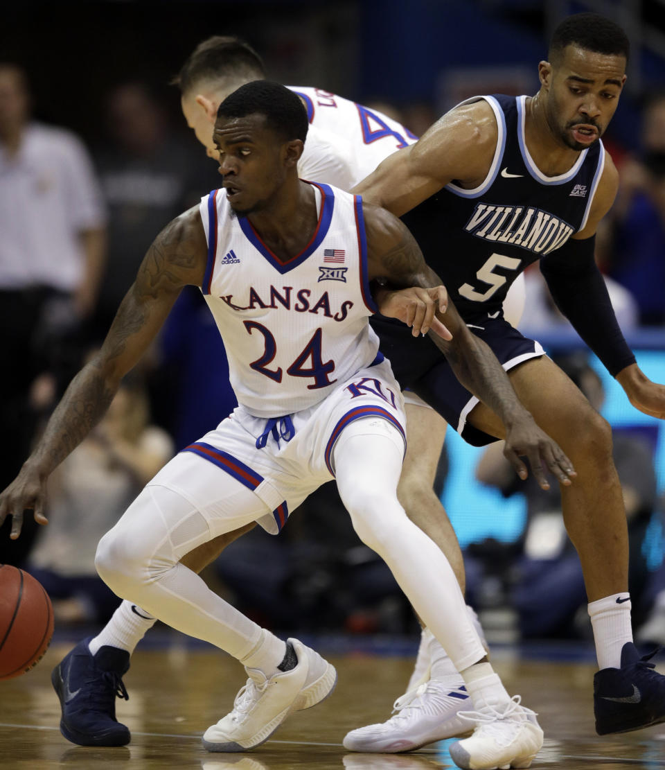 Kansas guard Lagerald Vick (24) locks arms with Villanova guard Phil Booth (5) during the second half of an NCAA college basketball game in Lawrence, Kan., Saturday, Dec. 15, 2018. Kansas defeated Villanova 74-71. (AP Photo/Orlin Wagner)