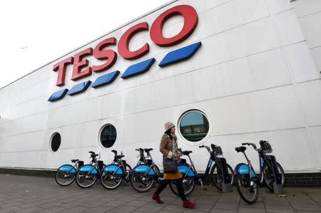 FILE PHOTO: A woman walks past a Tesco supermarket in central London, December 9, 2014. REUTERS/Toby Melville/File Photo