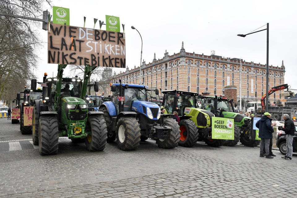 Farmers with their tractors block traffic on a road in the center of Brussels, during a demonstration, Friday, March 3, 2023. Hundreds of tractors driven by angry farmers protesting a plan to cut nitrate levels drove into Belgium's capital city on Friday causing major traffic disruption. Sign reads 'Who chokes the farmer will have nothing to eat'.(AP Photo/Geert Vanden Wijngaert)