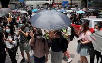 People wearing face masks take part in a protest against the second reading of a controversial national anthem law in Hong Kong