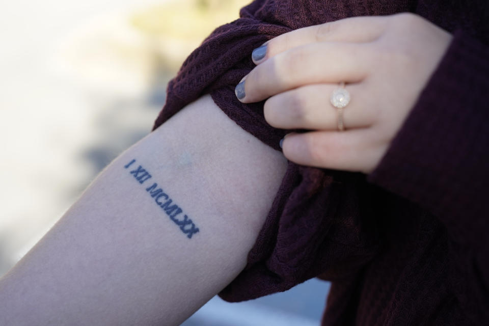 Lindsey Kirk shows a tattoo commemorating her late mother's birthday of Jan. 12, 1970, on Saturday, Nov. 13, 2021, in New Albany, Miss. She was 12 years old when her stepfather, David Neal Cox, terrorized her family, sexually assaulted her, and killed her mother, Kim Kirk Cox, in May 2010 at a home in Sherman, Miss. The Mississippi Supreme Court set an execution date of Wednesday, Nov. 17, 2021, for Cox after he said he wanted to surrender all appeals. (AP Photo/Rogelio V. Solis)