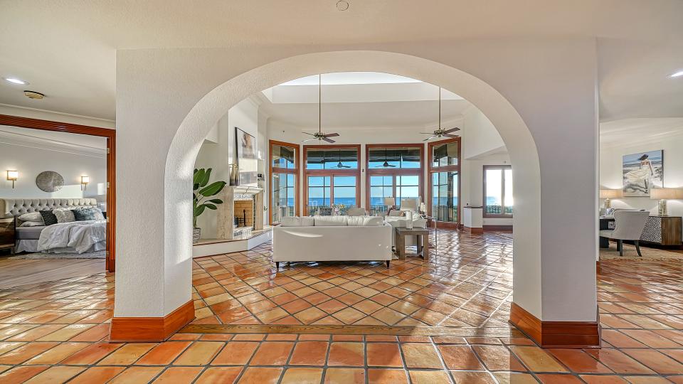 The floors are Spanish tile and mahogany framed arched French doors and windows open to the deck, swimming pool and the beach.