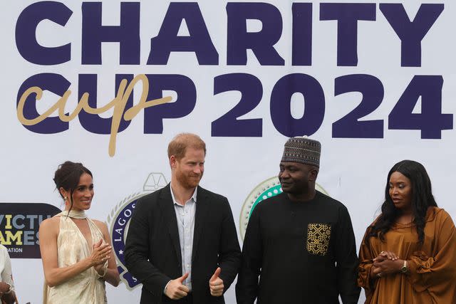 <p>KOLA SULAIMON/AFP via Getty</p> Meghan Markle and Prince Harry pose with the Nigerian Chief of Defense Staff Christopher Musa and his wife Lilian Musa at a charity polo match in Lagos, Nigeria on May 12, 2024.