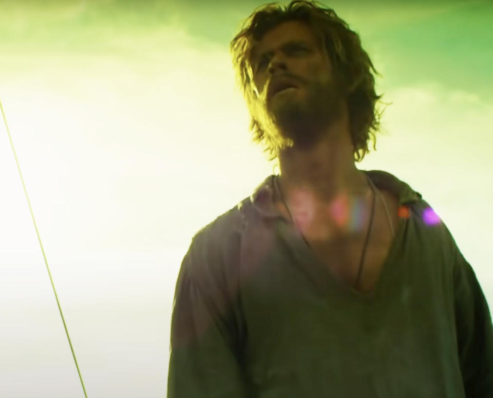 Chris Hemsworth, vêtu d'une chemise robuste, regarde le pont d'un navire dans une scène d'un film