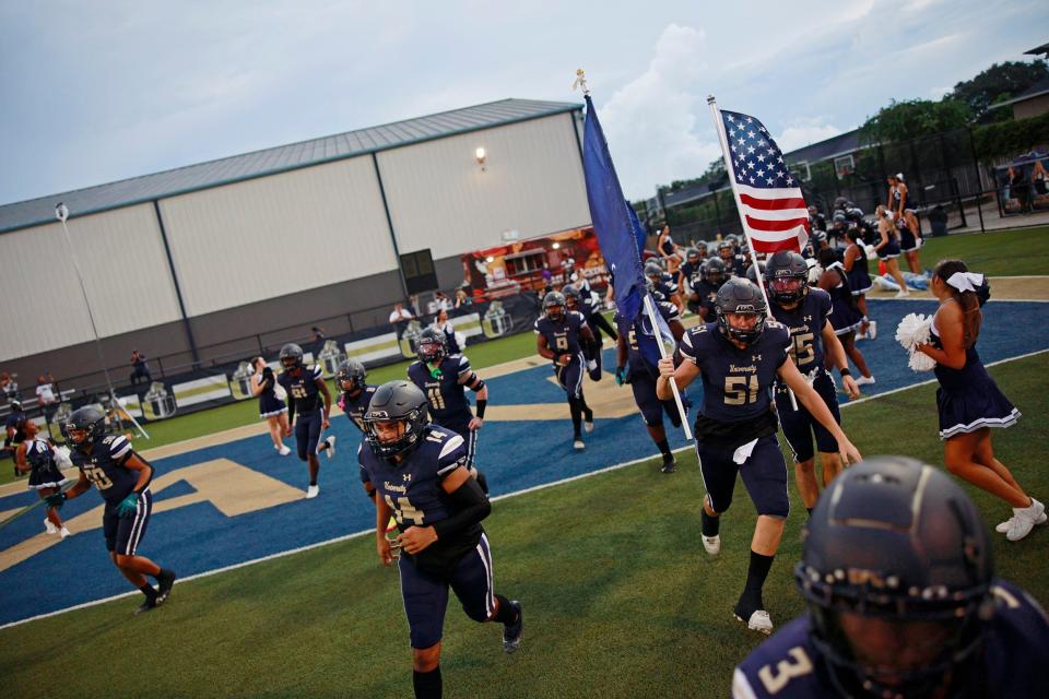 University Christian's Noah Clark (51) runs out with the school banner before an Aug. 26 game against Union County.