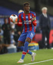 Crystal Palace's Wilfried Zaha prepares to throw the ball into pay during the English Premier League soccer match between Crystal Palace and Burnley at Selhurst Park, in London, England, Monday, June 29, 2020. (AP Photo/Hannah McKay,Pool)