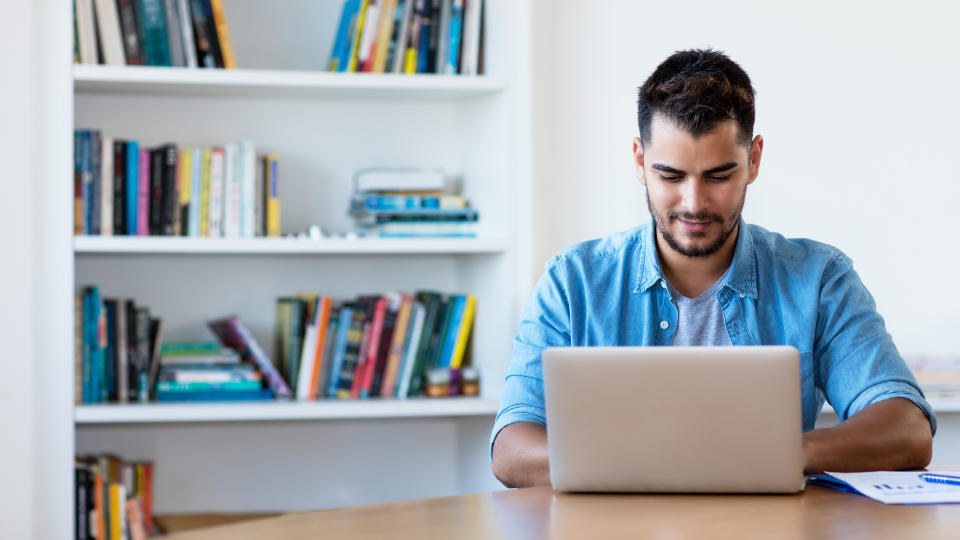 Man working with computer indoor at desk at home. Photo: Getty Images