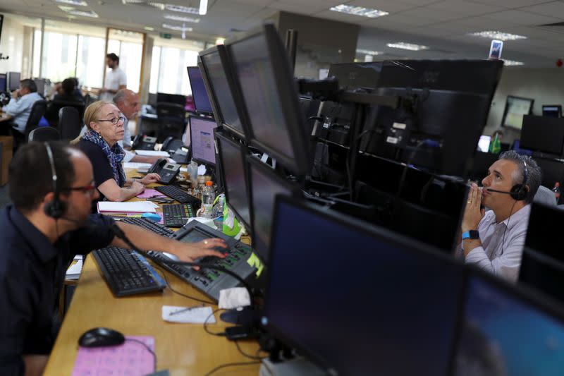 Traders work at Necton brokerage after an automatic circuit breaker was triggered twice today in Brazilian stock exchange in Sao Paulo