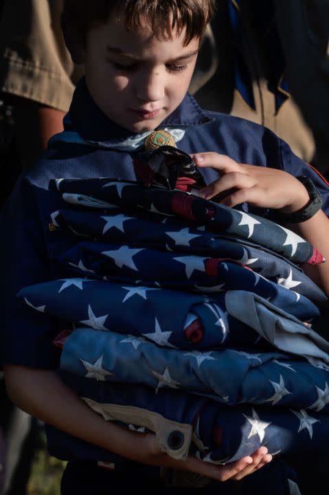 A Cub Scout holds a stack of American flags to be retired on Flag Day, June 14, 2022. (Photo by Aimee Dilger/SOPA Images/LightRocket via Getty Images)