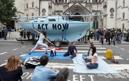 Extinction Rebellion climate activists hold a protest outside the Royal Courts of Justice in London