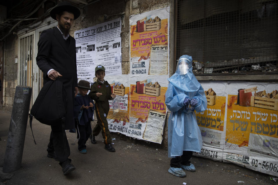 An ultra-Orthodox Jewish youth wears a costume of a medical worker with protective gear during celebrations of the Jewish holiday of Purim, in the Mea Shearim ultra-Orthodox neighborhood of Jerusalem, Sunday, Feb. 28, 2021. The Jewish holiday of Purim commemorates the Jews' salvation from genocide in ancient Persia, as recounted in the biblical Book of Esther. (AP Photo/Oded Balilty)