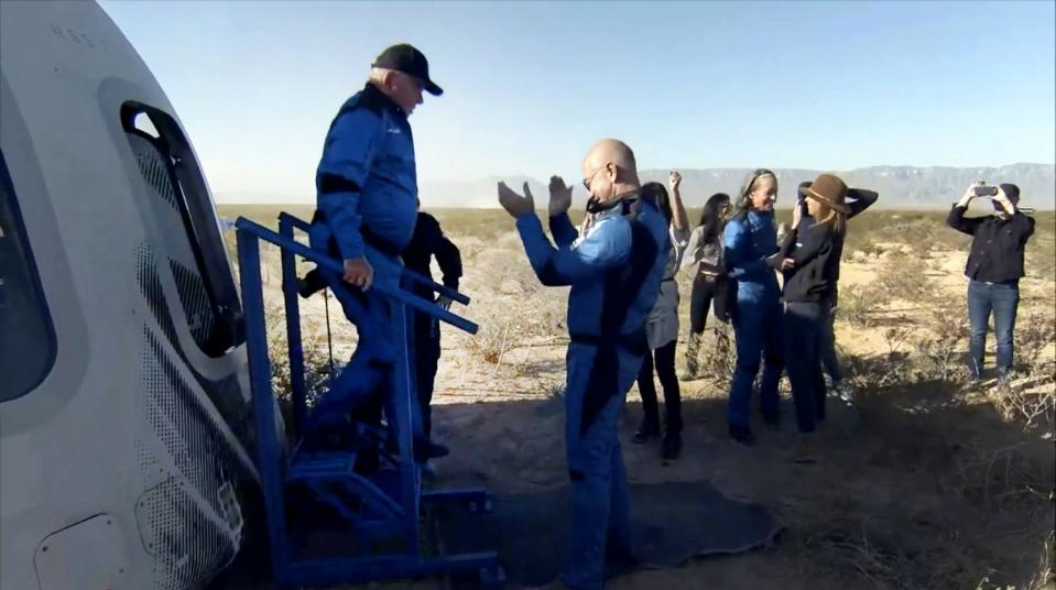 William Shatner is greeted by Jeff Bezos as he disembarks from the Blue Origin capsule.