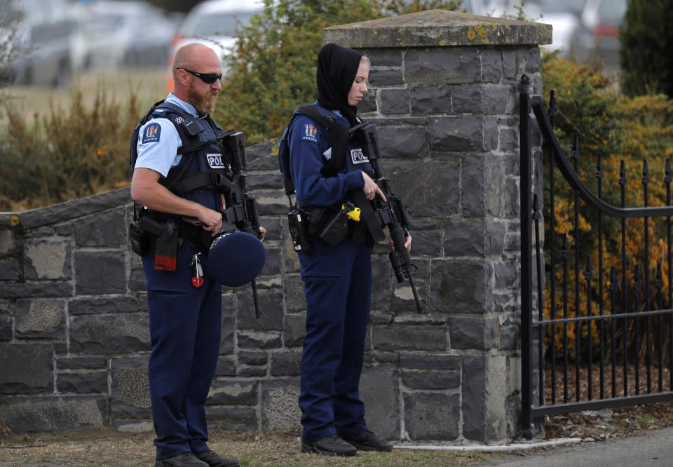 Oficiales de policía muestran sus respetos a la llegada de una carroza fúnebre con el cuerpo de una víctima del tiroteo del 15 de marzo en el cementerio de Christchurch, Nueva Zelanda, el jueves 21 de marzo de 2019. (AP Foto/Vincent Yu)