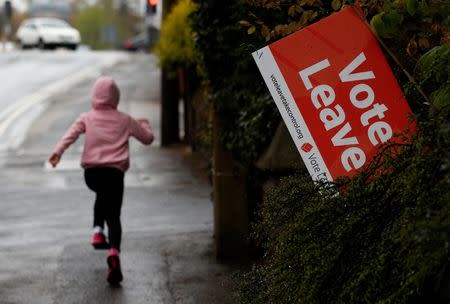 A girl runs past a Vote Leave sign, protruding from the garden of a house in Altrincham, northern England, Britain May 2, 2016. REUTERS/Phil Noble