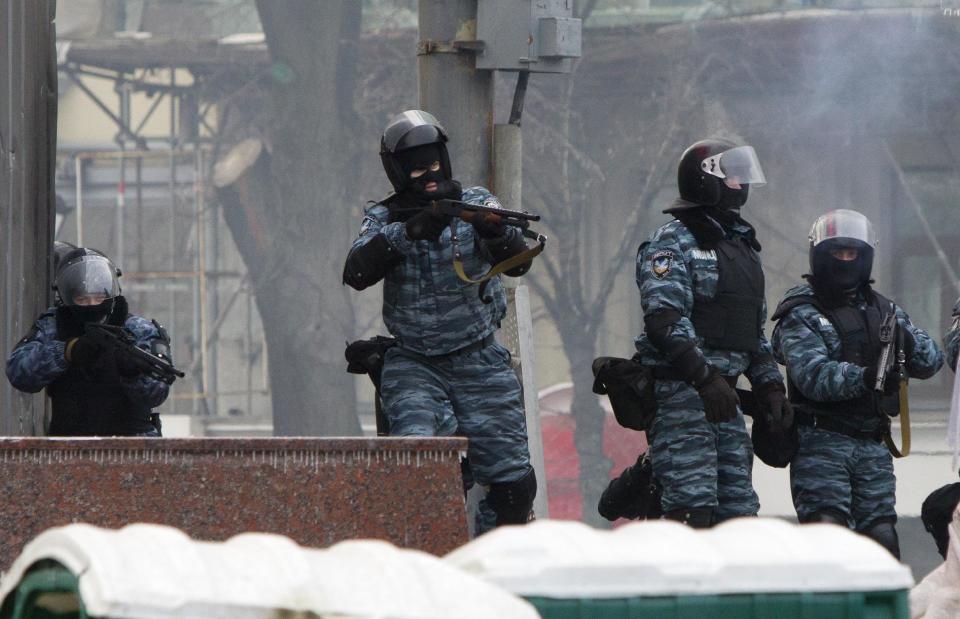 Riot police officers shoot rubber bullets at anti-government protesters, during unrest in central Kiev, Ukraine, Monday, Jan. 20, 2014. Protesters erected barricades from charred vehicles in central Kiev as the sound of stun grenades pierced the freezing air, after a night of rioting sparked by passage of laws aims at curbing street protests. (AP Photo/Sergei Chuzavkov)