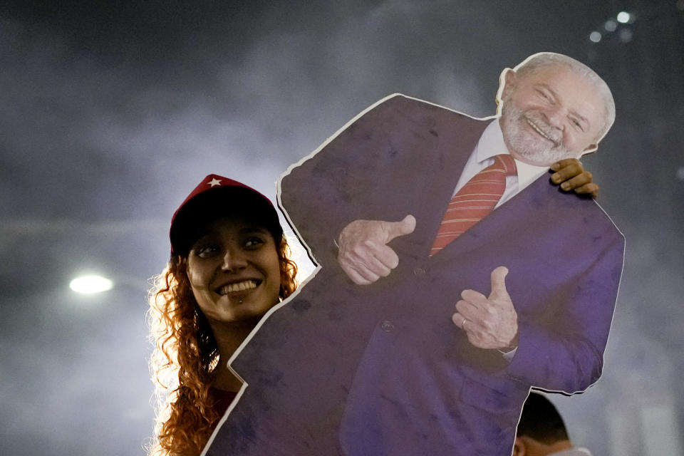 A follower of former Brazilian President Luiz Inacio "Lula" da Silva, who is again running for president, celebrates as she listens to the partial results after general election polls closed in Rio de Janeiro, Brazil, Sunday, Oct. 2, 2022. (AP Photo/Silvia Izquierdo)