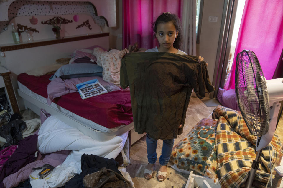 FILE - Rimas, displays the bloodstained t-shirt of her brother, Palestinian Mohammed al-Shaham, 21, who was shot and killed inside his home during an early morning Israeli police raid, in the east Jerusalem neighborhood of Kafr Aqab, Aug. 15, 2022. At least 85 Palestinians have been killed in the West Bank this year as Israeli forces have carried out nightly raids in cities, towns and villages, making it the deadliest in the occupied territory since 2016. (AP Photo/Nasser Nasser, File)