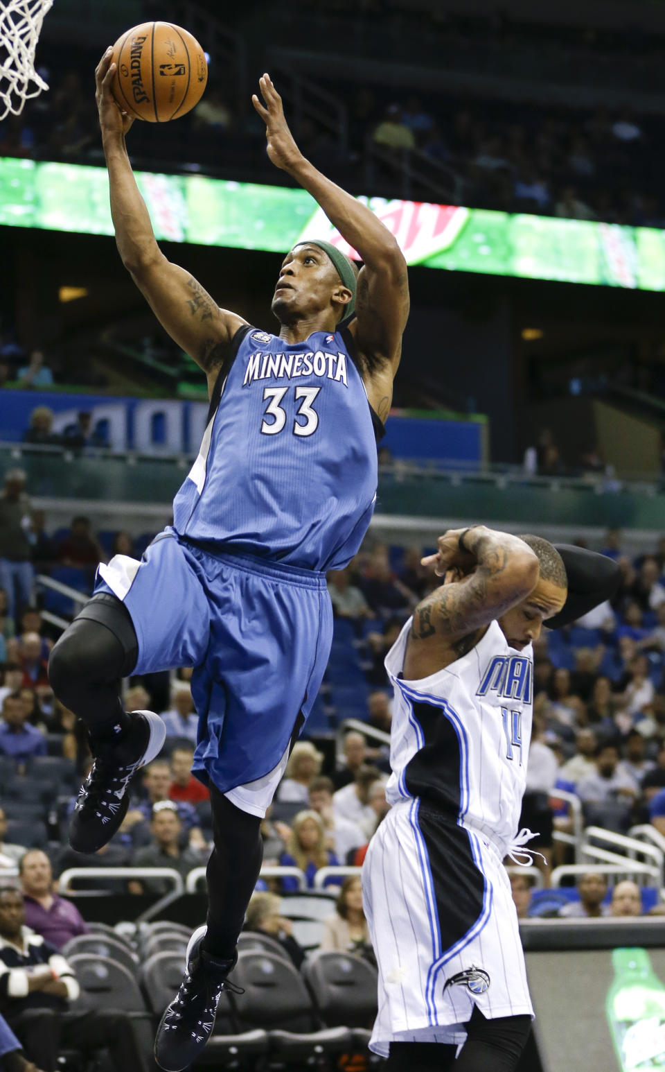 Minnesota Timberwolves' Dante Cunningham (33) gets past Orlando Magic's Jameer Nelson for a basket during the first half of an NBA basketball game in Orlando, Fla., Saturday, April 5, 2014. (AP Photo/John Raoux)