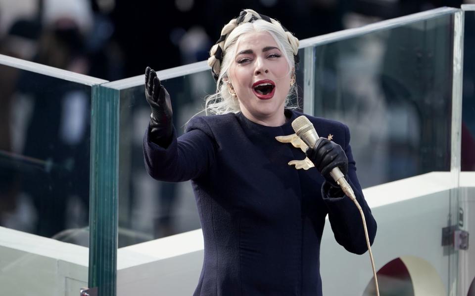 Nicht ihr ausgefallenster Auftritt, aber definitiv einer, an den man sich noch lange erinnern wird: Im Januar 2021 durfte Lady Gaga bei der Amtseinführung von US-Präsident Joe Biden die Nationalhymne singen - und weil damit nicht zu spaßen ist, legte die Gaga hier auch eine hochseriöse Performance ohne irgendwelche Verrücktheiten hin. (Bild: Bloomberg/Greg Nash/The Hill/Getty Images)