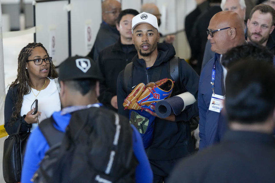 Los Angeles Dodgers outfielder Mookie Betts, center, walks with his wife Brianna Betts, left, during the baseball team's arrival at Incheon International Airport, Friday, March 15, 2024, in Incheon, South Korea, ahead of the team's baseball series against the San Diego Padres. (AP Photo/Ahn Young-joon)