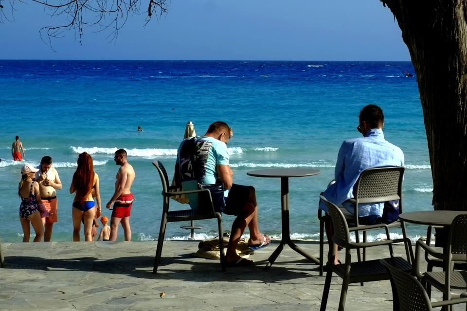 Tourist and local vacationed enjoy the sea at a popular "Nissi Beach" in southeast resort of Ayia Napa, in the eastern Mediterranean island of Cyprus, Saturday, May 22, 2021. Cypriot hotel and other tourism-related business owners say they'd like to see the COVID-19 pandemic-induced uncertainty over travel bookings to the tourism-reliant island nation winding down by July when they're hoping authorities in Cyprus' main markets including the U.K., Russia, Germany and the Scandinavian countries will make it easier for their citizens to travel abroad. (AP Photo/Petros Karadjias)