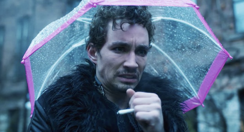 Robert in "Umbrella Academy," holding a cigarette and pink umbrella