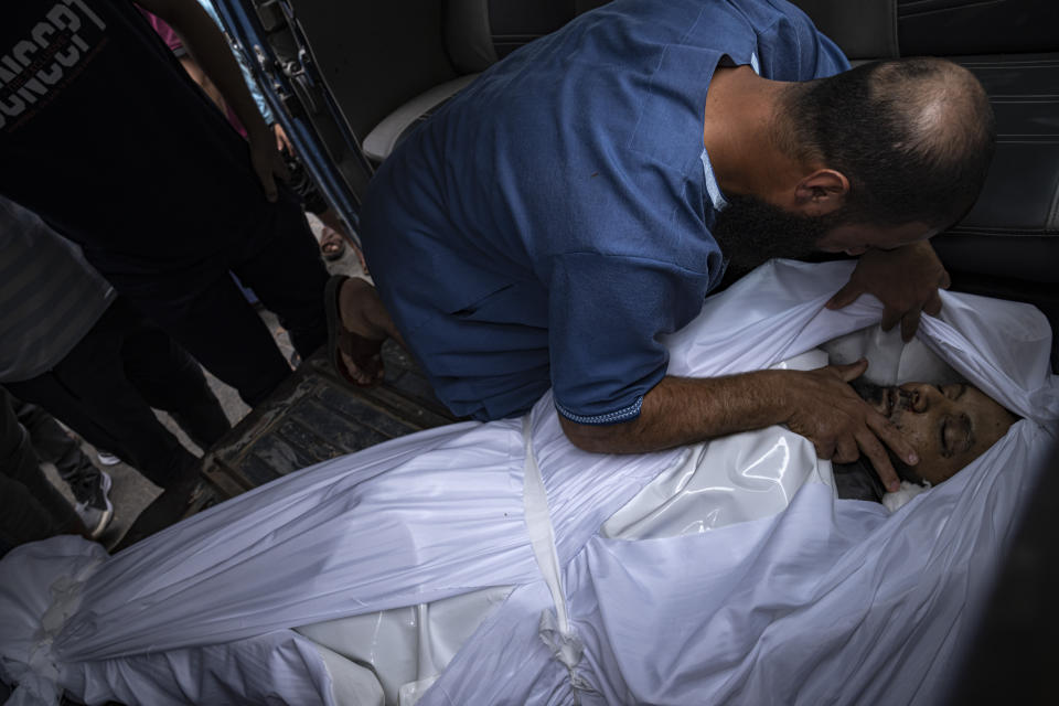 A relative mourns over a man killed in an Israeli air strike in Gaza City on Monday, Oct. 9, 2023. Israel's military battled to drive Hamas fighters out of southern towns and seal its borders Monday as it pounded the Gaza Strip. (AP Photo/Fatima Shbair)