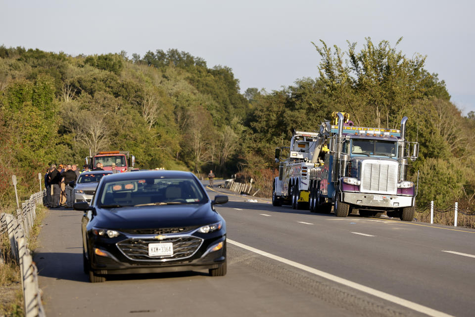 Emergency responders gather near the scene of a fatal bus crash, in Wawayanda, N.Y., Thursday, Sept. 21, 2023. A charter bus carrying high school students to a band camp hurtled off a New York highway and down an embankment, officials said. (AP Photo/Adam Hunger)