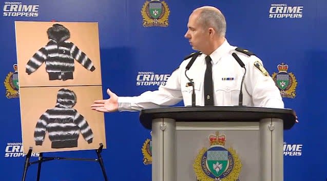 Winnipeg police Insp. Shawn Pike gestures to images of a jacket that investigators hope will help identify an unknown victim of an alleged serial killer in Winnipeg. The woman is being called Mashkode Bizhiki'ikwe, or Buffalo Woman.