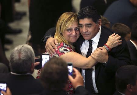 Former soccer star Diego Maradona (R) takes a picture with a fan as he arrives to meet Pope Francis, for a special audience held before a special interreligious "Match for Peace", at the Paul VI hall at the Vatican September 1, 2014. REUTERS/Alessandro Bianchi