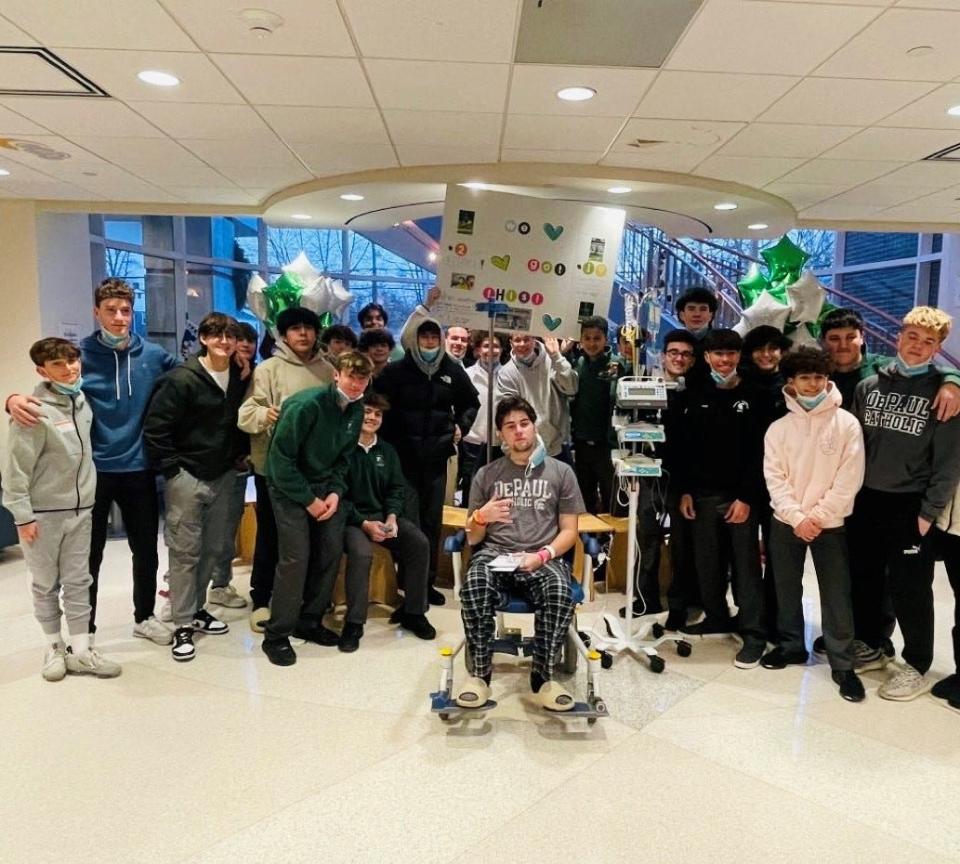 The DePaul High School soccer team visiting teammate Marko Dobre at Morristown Medical Center this winter as he battles cancer. They're holding a poster that says "We Got This."